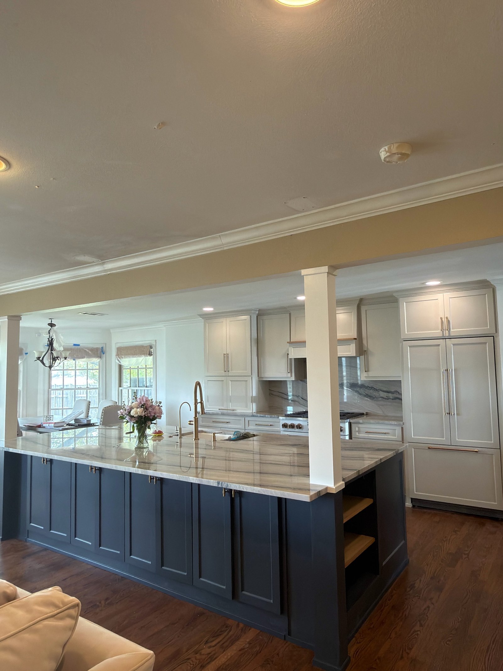 Navy blue island kitchen with white upper cabinets