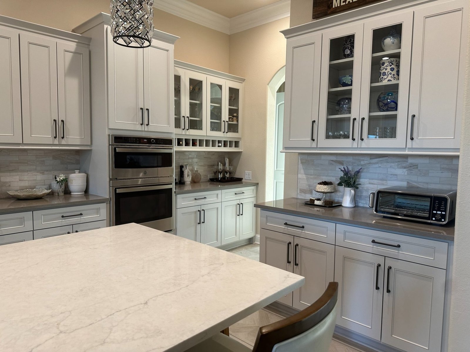White kitchen with glass front cabinets and wine rack