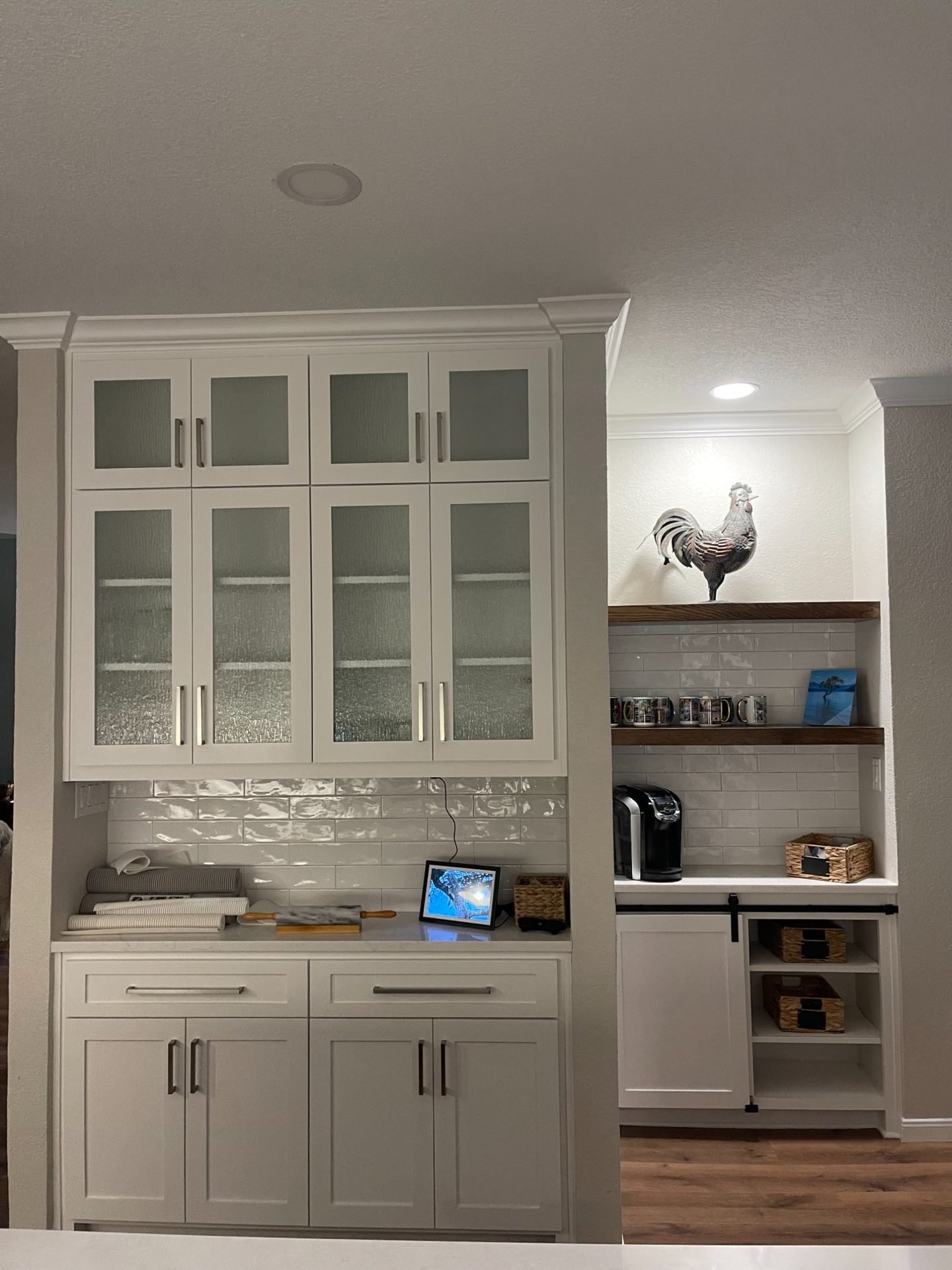 White shaker kitchen with glass front cabinets and coffee station